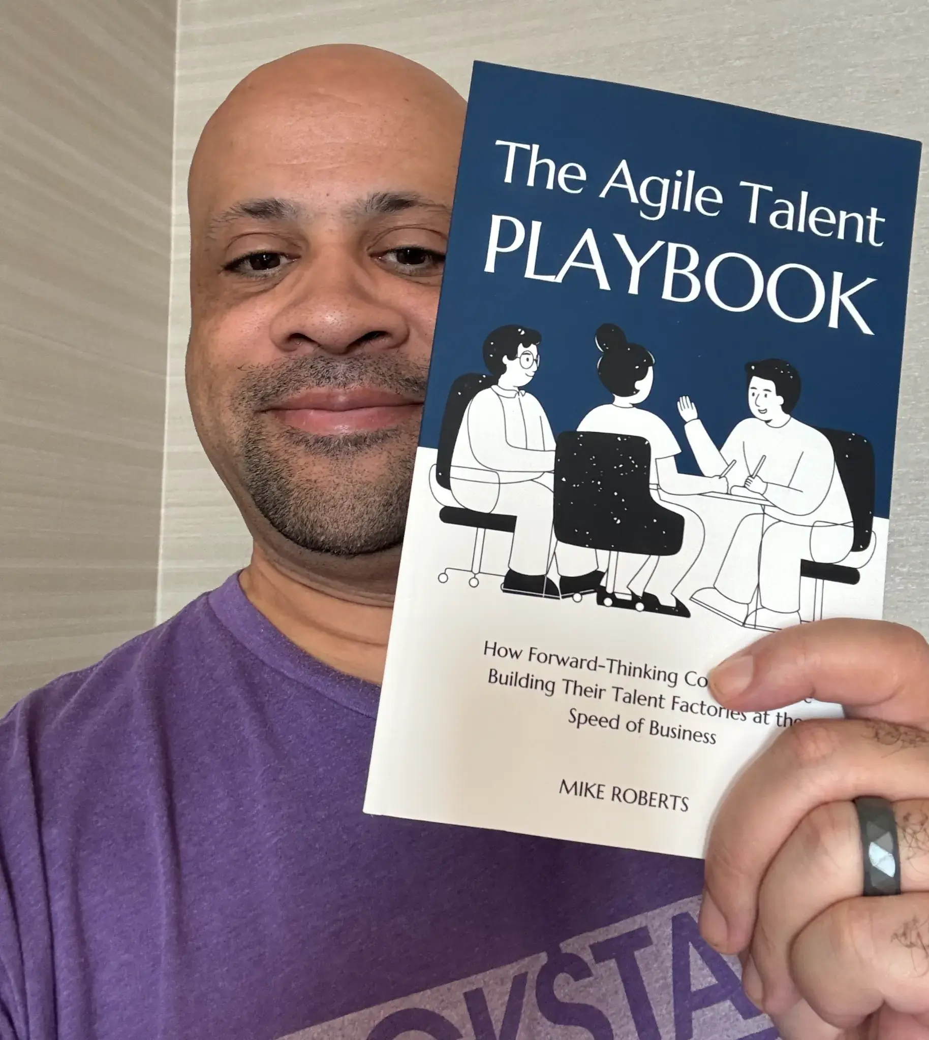 Mike Roberts holding The Agile Talent Playbook
